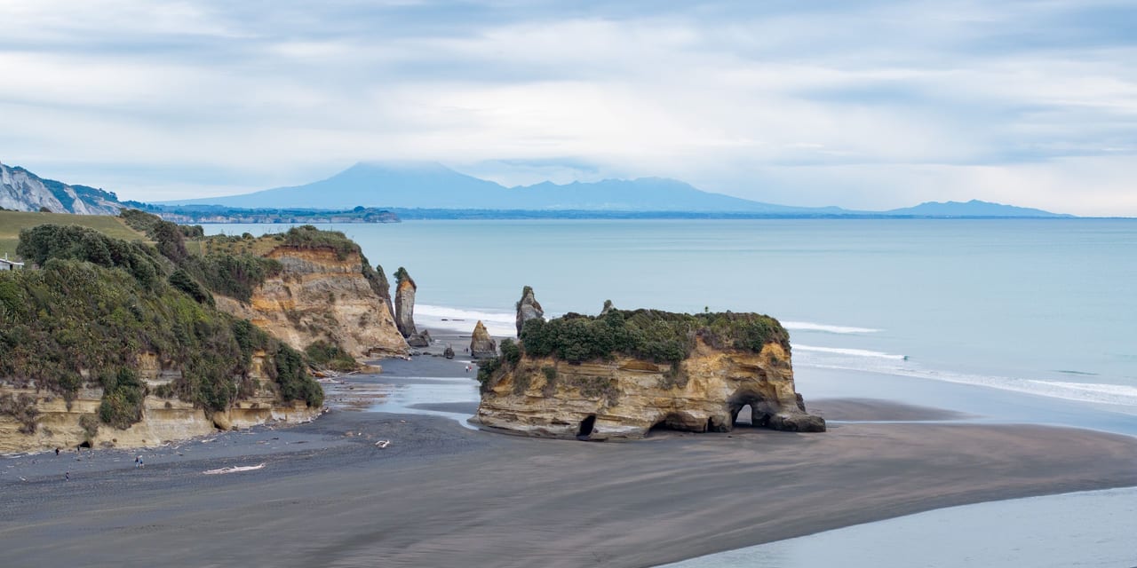 A panoramic view of cliffs and ocean at a beach.