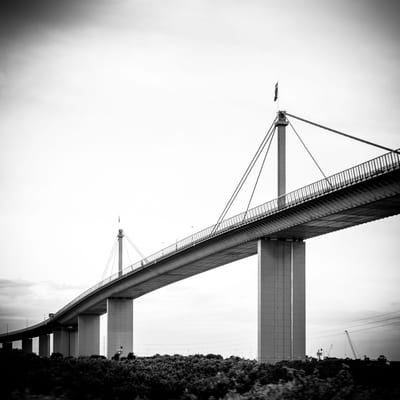 A large bridge with a modern design spanning over a landscape.